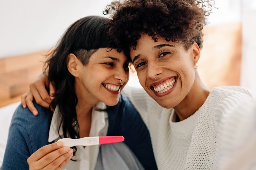 weibliches paar das selfie ihrer positiven test schwangerschaft macht