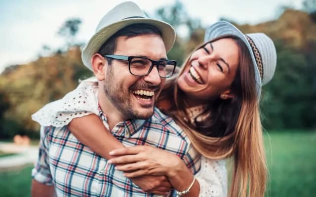 Co-Parenting Partner lachen gemeinsam im Freien und zeigen eine vertrauensvolle Beziehung