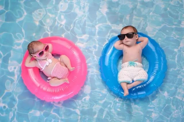 Zwei Monate alte Baby Zwillinge Bruder und Schwester auf rosa und blauen Bojen illustrieren Geschlecht Baby beeinflussen Methoden