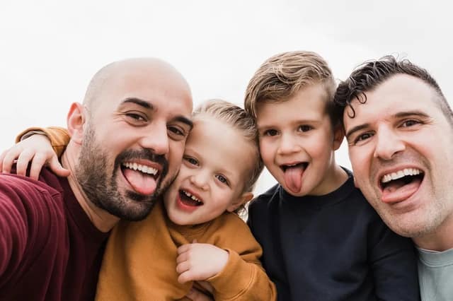 Regenbogenfamilie Kindern und zwei Vätern beim gemeinsamen Moment