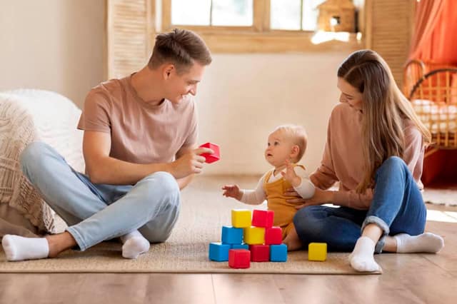 Fürsorgliche Eltern spielen mit ihrem kleinen Sohn zu Hause und zeigen was ist Co-Parenting in der Praxis
