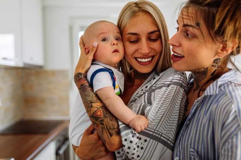 Porträt von zwei jungen lesbischen weiblichen paaren mit ihrem baby