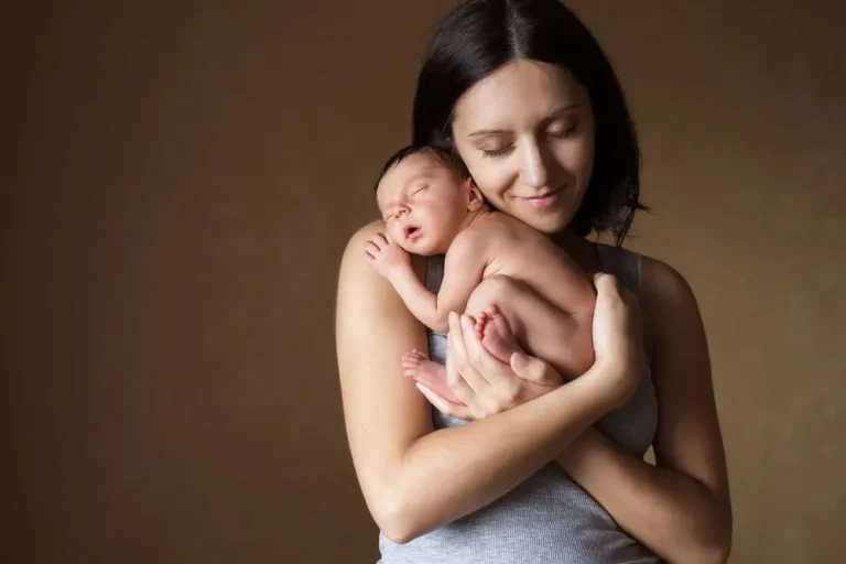 Alleine Baby bekommen junge Mutter hält liebevoll ihr neugeborenes Baby im Arm