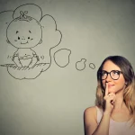 Nachdenkliche Frau mit einseitiger Kinderwunsch träumt von einem Baby und reflektiert über ihren Kinderwunsch