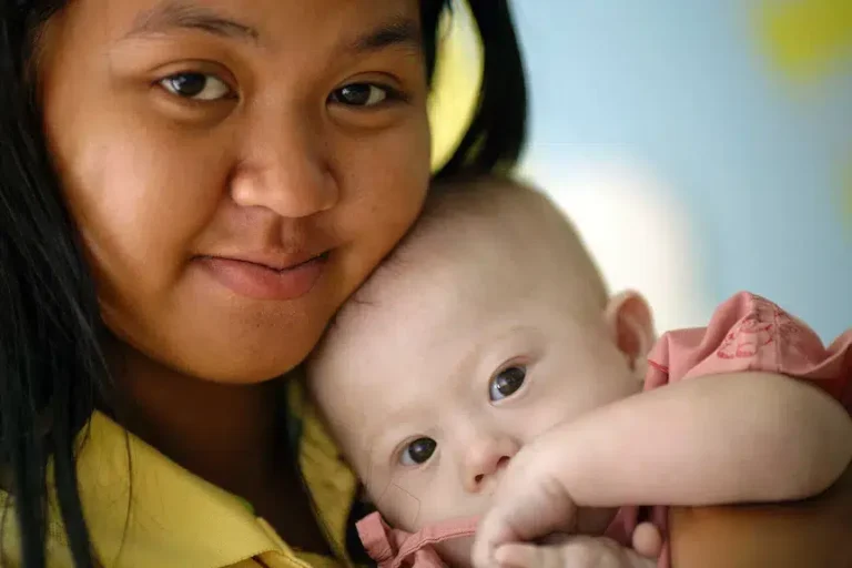 Baby Gammy mit seiner Mutter in einer emotionalen Nahaufnahme liebevoll im Arm gehalten