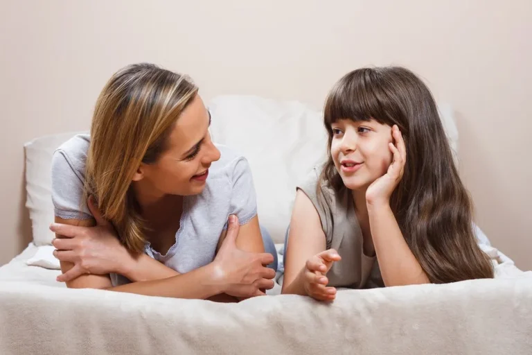 Mutter und Tochter liegen auf dem Bett und reden vertraulich um Kind Samenspende erklären in altersgerechter Weise