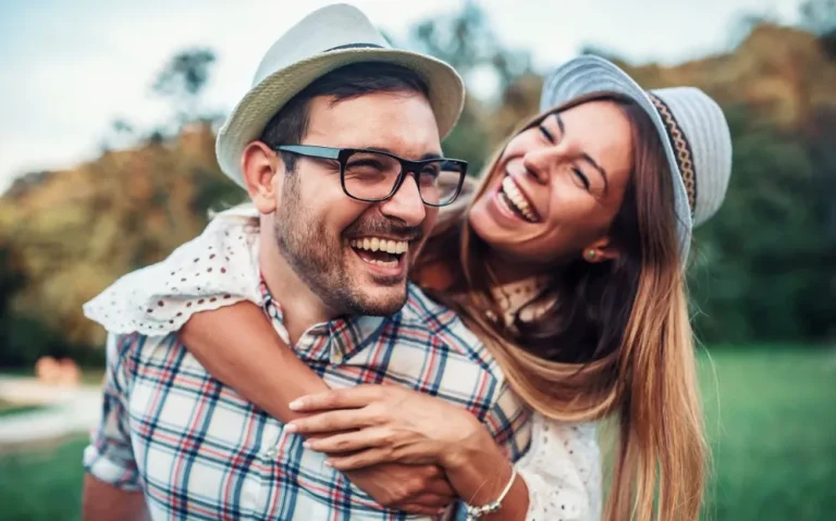Co-Parenting Partner lachen gemeinsam im Freien und zeigen eine vertrauensvolle Beziehung